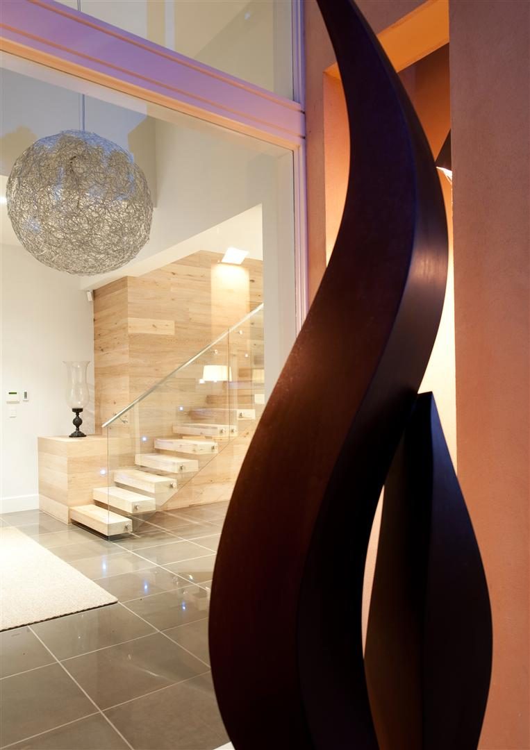Interior detail — sculptural forms set against the white floating timber stair