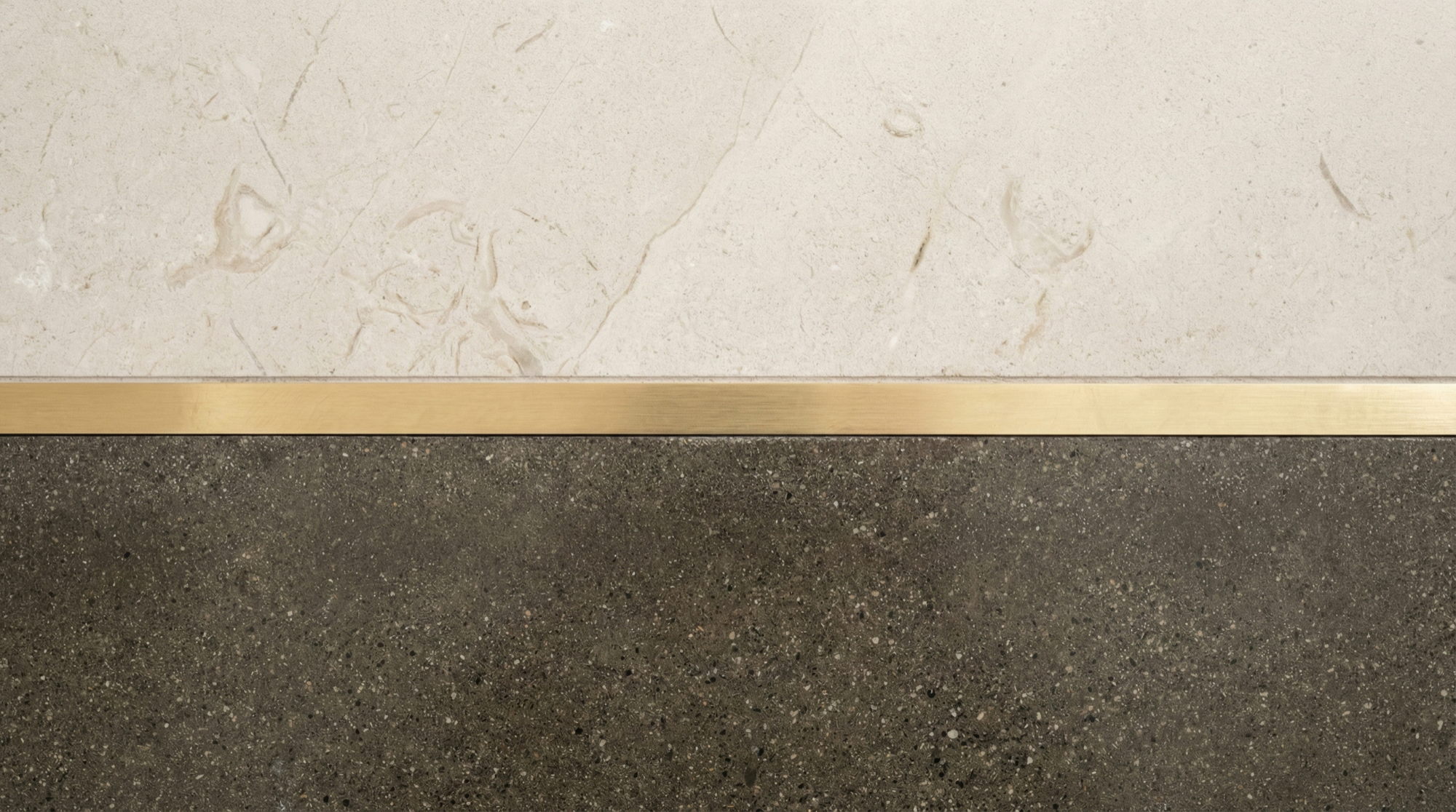 Brass inlay at a threshold junction — where two materials meet with zero tolerance